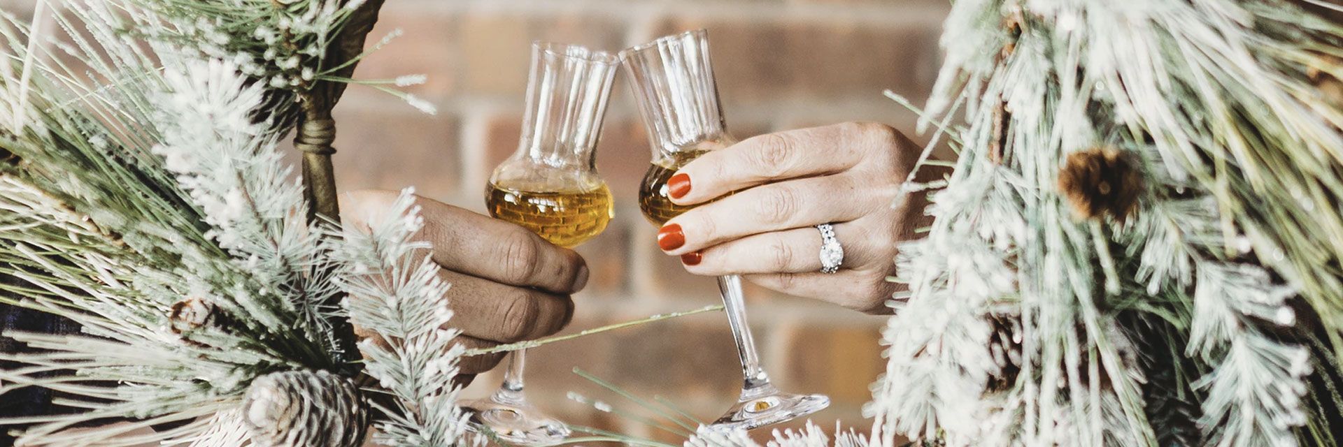 mand and woman's hands clinking icewine glasses