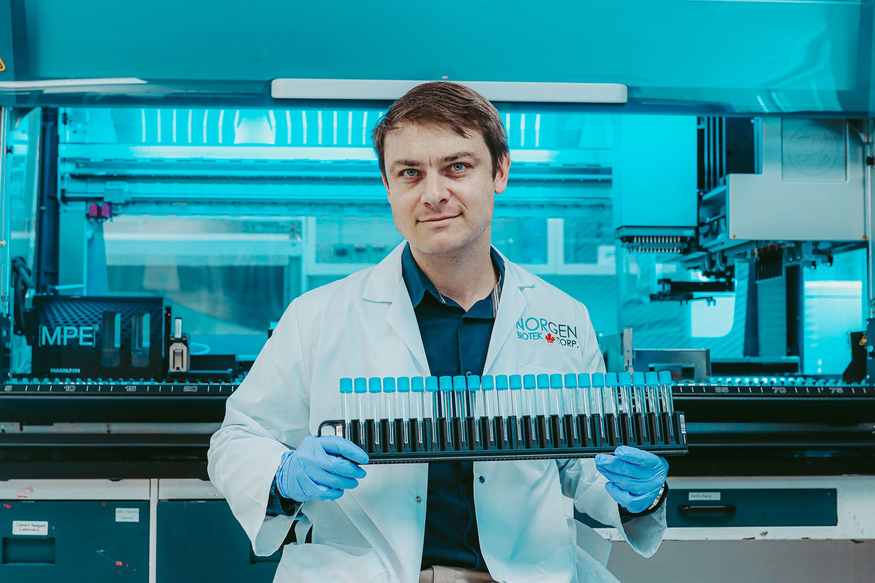 Norgen scientist holding row of columns ready for automation